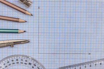 Measuring tools above  blue graph paper.