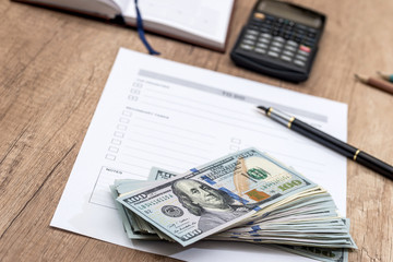 dollars and calculator with blank sheet on the table