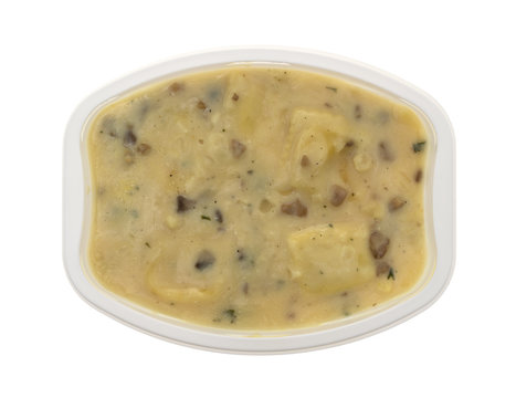 Ravioli in a cheese and mushroom sauce TV dinner in a plastic tray isolated on a white background.