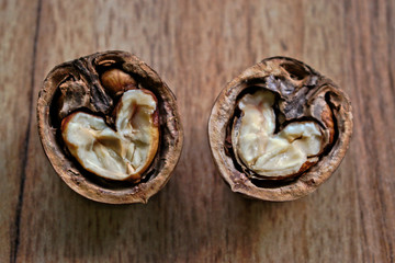 Two walnut halves with heart shaped cores on a wooden table