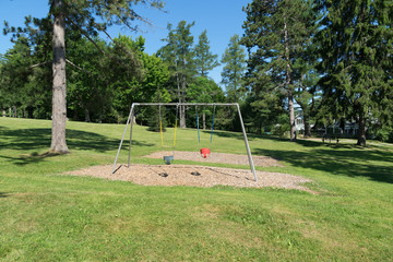 Empty toddler swing set in park setting