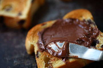 Spreading hazelnut chocolate on toasted chocolate chip brioche slices