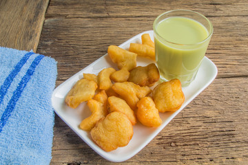green soybean milk and deep-fried doughstick on wood background