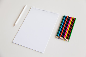 Blank sheet of paper and pencils on a white background. Branding Mock-Up.
