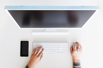 Man hand on desktop keyboard with blank screen monitor. White background. Branding Mock-Up.