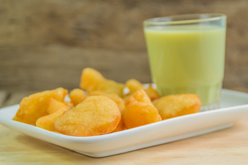 green soybean milk and deep-fried doughstick on wood background