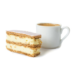 Sweet cake. Puff cake with cream. Cup with black coffee in the background. Selective focus. Isolated objects on a white background.