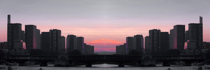 Obraz premium Cityscape with buildings, bridge, river and red sunset sky. Selective focus. Copy space. Toned image. Wide panoramic image.