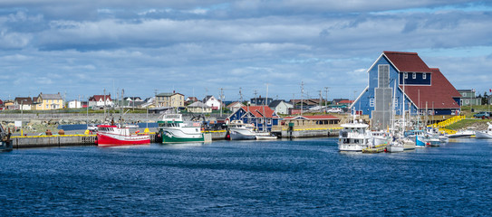 Bonavista, Newfoundland fishing villages.   Boats tied up for the day on calm coastal water.  - 131647962