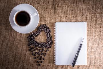 Roasted coffee beans in the shape of a heart and coffee cup, not
