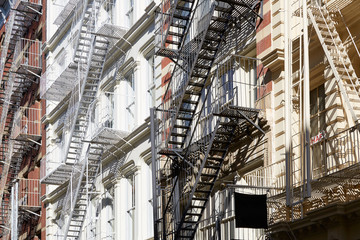 Fototapety  Houses facades with fire escape stairs, sunny day in New York