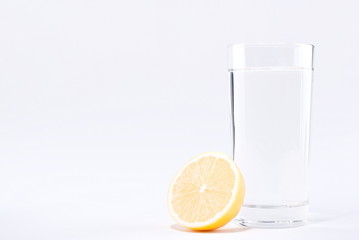 glass of water with lemon on a white background