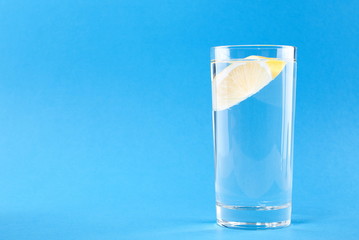 glass of water with lemon on a blue background