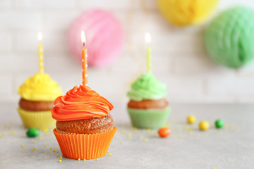 Fresh tasty cupcakes and birthday decor on blurred background