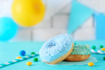 Two donuts and Birthday decor on blurred brick wall background