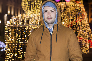 young man smiling on the street on a bokeh background.Holidays concept