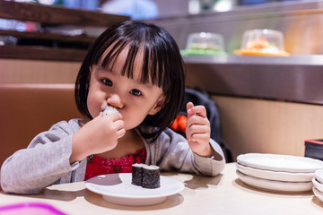 Asian Chinese little girl eating sushi at a Japanese restaurant © Tan Kian Khoon