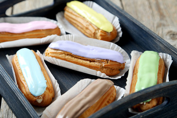 Eclairs with glaze on a grey wooden table