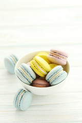 French colorful macarons on a white wooden table