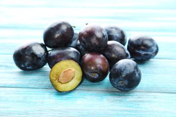 Tasty and ripe plums on blue wooden table