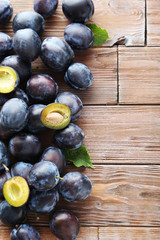 Tasty and ripe plums on brown wooden table