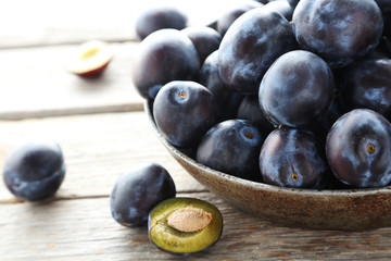 Tasty and ripe plums on grey wooden table