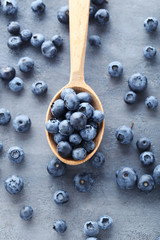Ripe and tasty blueberries on grey wooden table