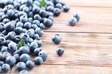 Ripe and tasty blueberries on brown wooden table