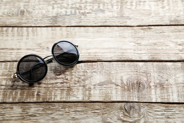 Black sunglasses on a grey wooden table