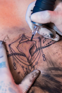 Tattooist doing tattoo with professional machine