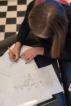 Attractive blonde woman creating sketch for tattoo