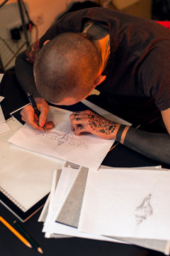 Tattooer creating sketch for tattoo
