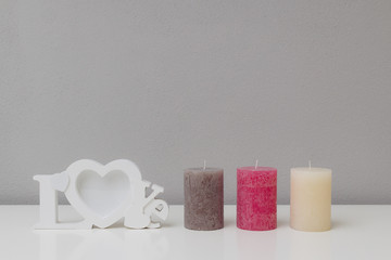 Three candles with a heart shaped love photo frame