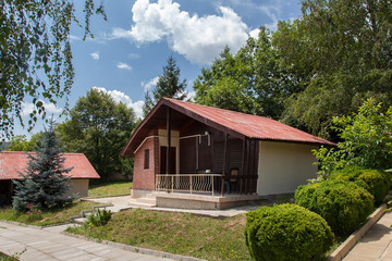 Fototapeta na wymiar Wooden bungalows and garden in the forest. Holiday apartments