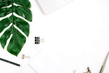 Home office workspace frame with laptop, palm leaf and accessories. Flat lay, top view