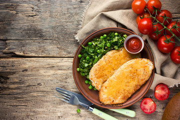Fried chicken fillet with cheese crust and garnish