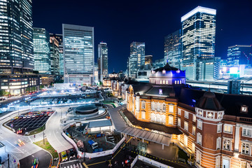 Asia Business concept for real estate and corporate construction - panoramic modern cityscape building bird eye aerial night view of Tokyo Station under neon light and dark blue sky in Tokyo, Japan