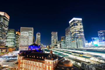 Fototapeta premium Business concept for real estate and corporate construction - panoramic modern city skyline bird eye aerial night view with tokyo station under dramatic glow and beautiful dark blue sky in Tokyo,Japan