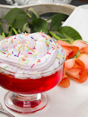 Colorful jelly with whipped cream and candy topping