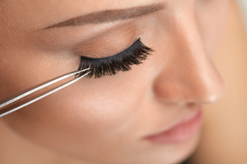 Beauty Makeup. Woman Applying Black False Eyelashes With Tweezer