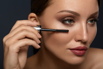 Beauty Woman Makeup. Beautiful Woman Applying Black Mascara