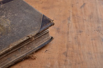 Old leather bound book laying on an old rustic wood