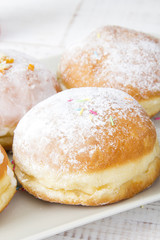 donuts with frosting and powdered sugar on a platter