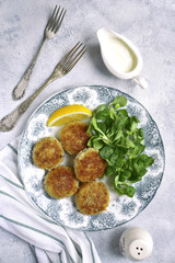 Fish cutlets with cream sauce on a vintage plate.Top view.