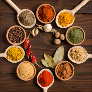 Various spices in bowls and mixing spoons  - Top view