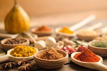 Colorful spices and dried herbs on wooden table