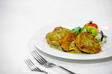 pancakes made from potatoes with a garnish on a plate.