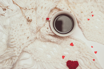 Cup of coffee with warm knitted scarf