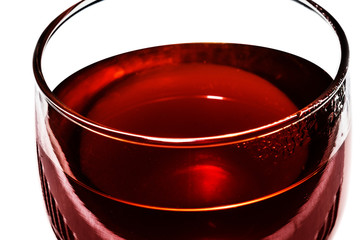 Close the transparent cup of red tea, isolated on a white background