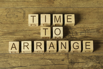 time to arrange text on wooden cubes on a wooden background